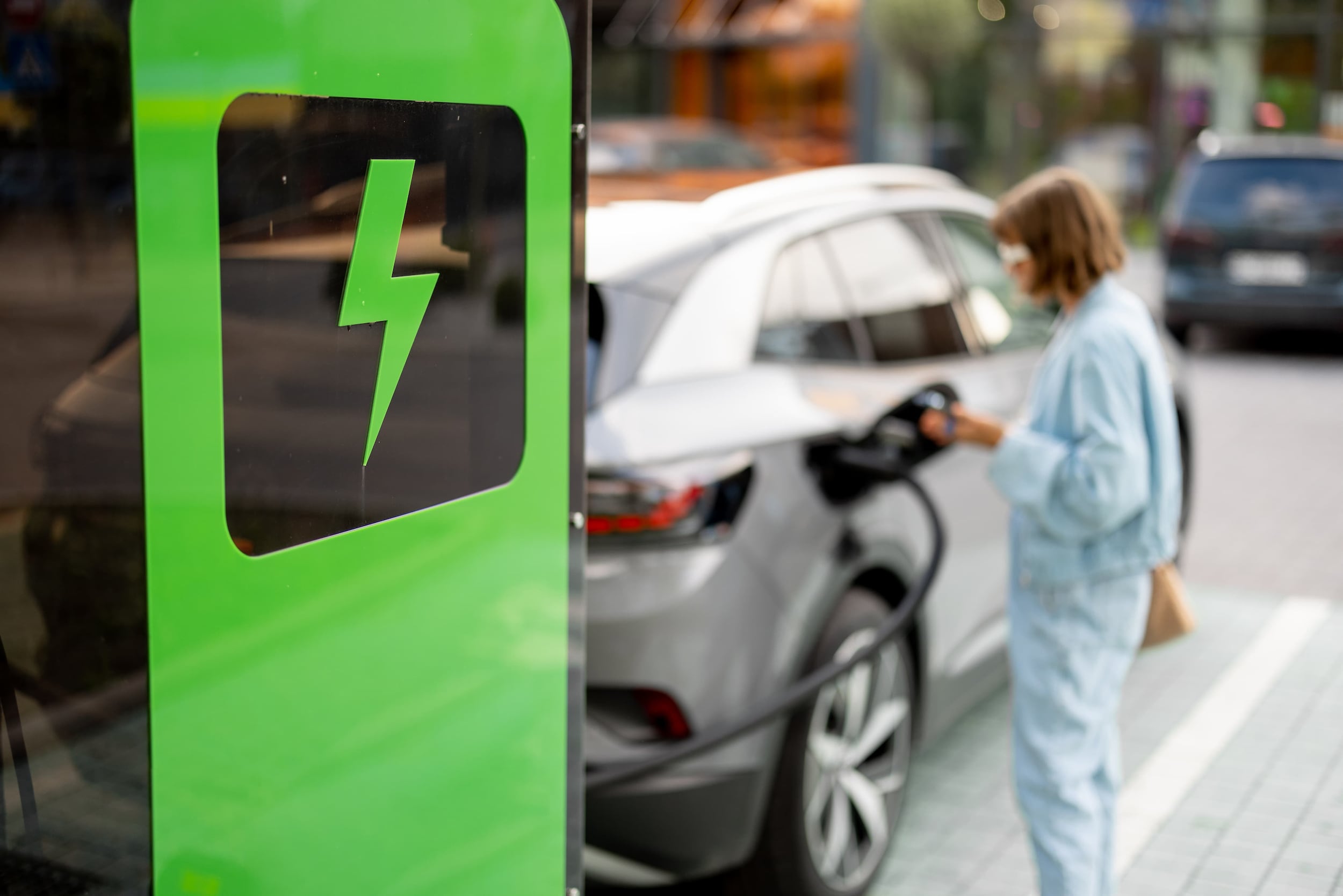 woman-charging-her-car-on-public-fast-charger-2023-11-27-04-51-43-utc%20(1).jpg