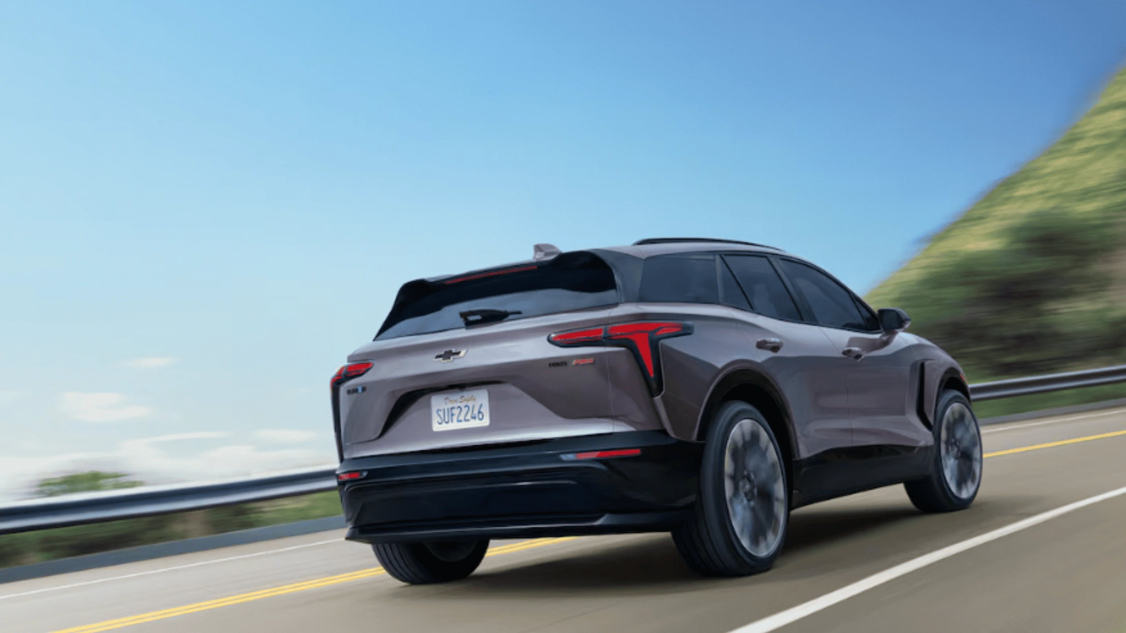 2026 Chevrolet Blazer EV in purple shown from the rear on a highway, showcasing sleek electric design near Fort Bragg, NC.
