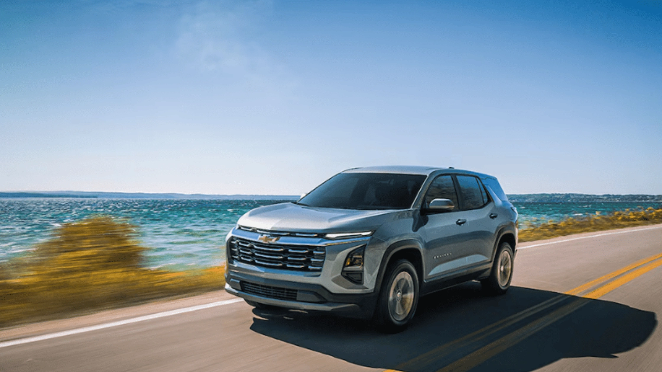 2026 Chevrolet Equinox in silver driving by the ocean, emphasizing comfort and technology for families near Fort Bragg, NC.