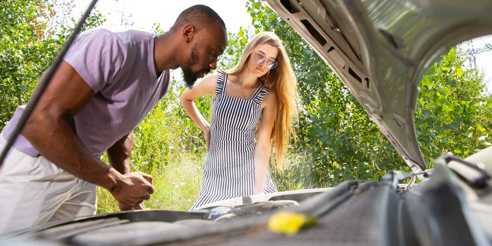 Couple stuck on the side of the road in summer