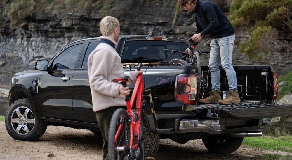 People loading bikes into a black 2024 Ford Ranger XLT.