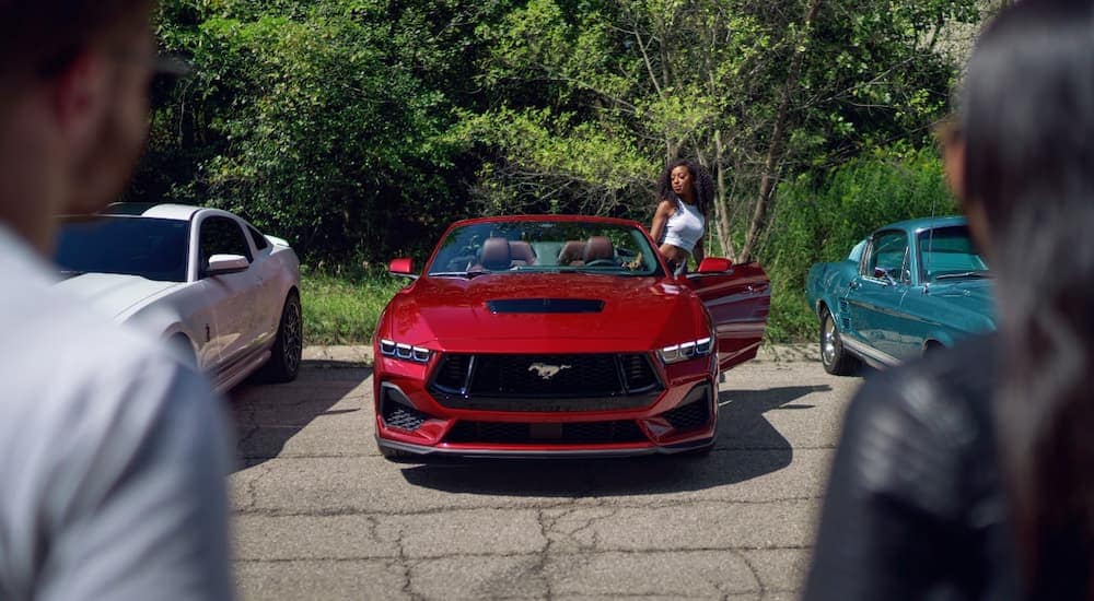 A woman getting into a red 2024 Mustang parked at a Ford dealer near you.