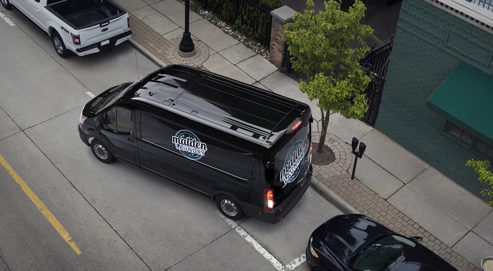 Aerial view of a black 023 Ford Transit parallel parking.