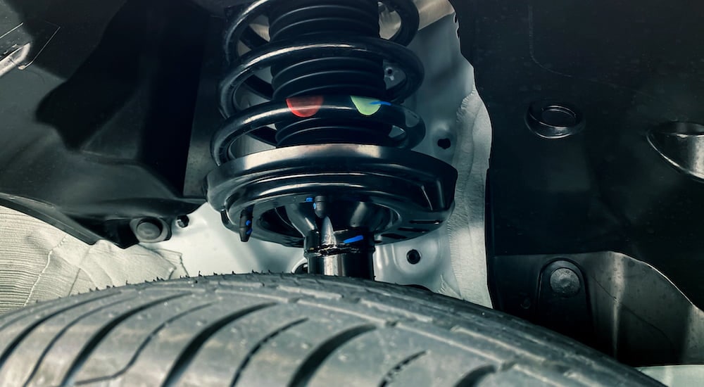 A close-up shows a car's suspension at a Ford service center near Brooklyn.