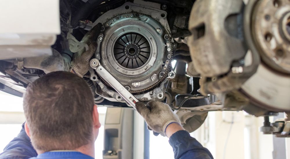 A tech is shown working on the clutch of a vehicle.