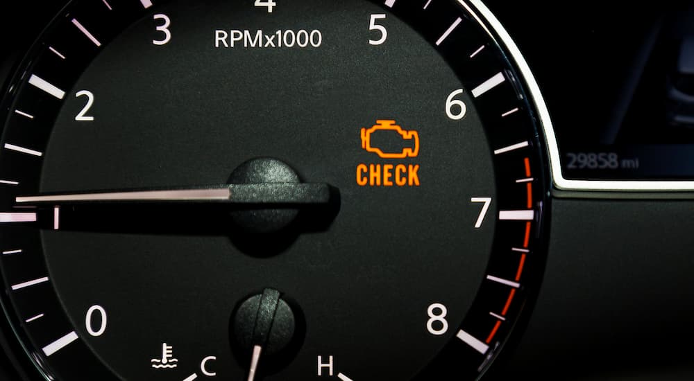 A close up of the check engine light on a vehicle is shown before getting 'auto repair near me' done.
