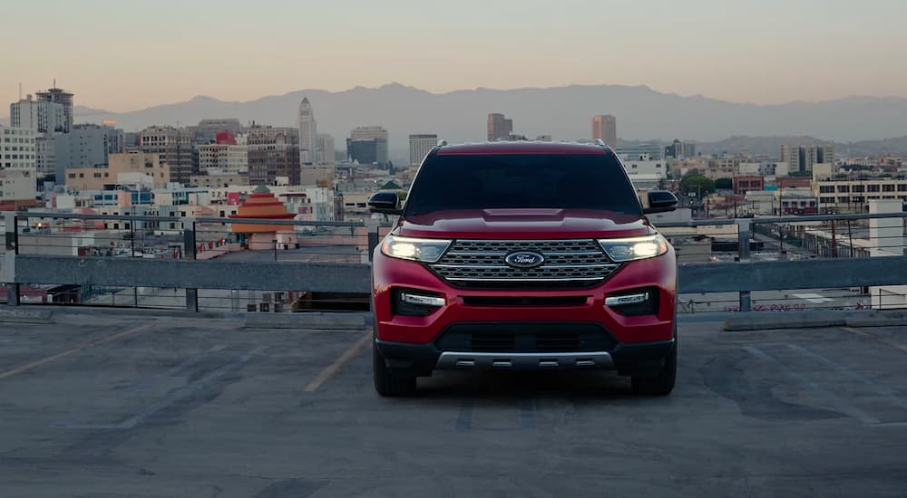 A red 2023 Ford Explorer Limited Hybrid parked on a city rooftop after leaving a Brooklyn Ford Dealer.