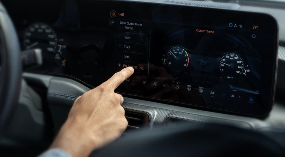 A person using the touch screen in a 2024 Ford Mustang.