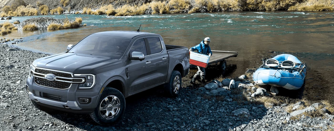 A man unloads a boat from the trailer towed by a grey 2024 Ford Ranger.