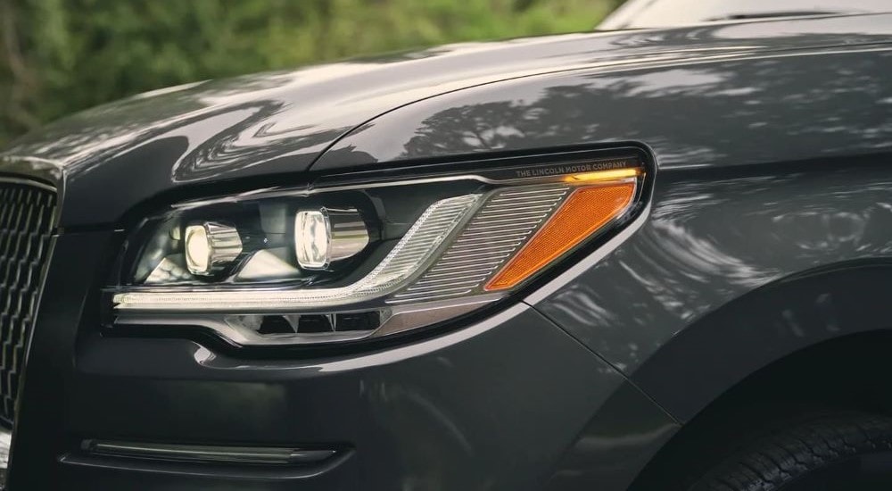 A close up of the driver side headlight on a grey 2023 Lincoln Navigator.