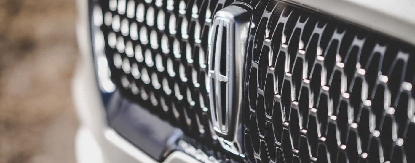 A close up of the grille on a white 2023 Lincoln Aviator.