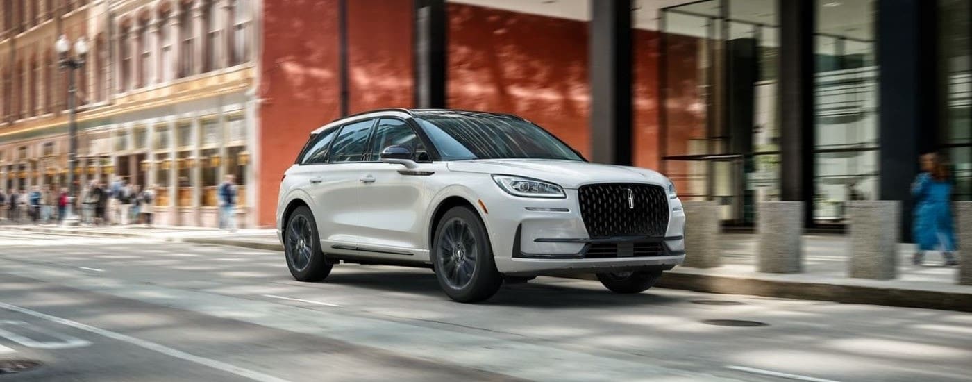 A white 2023 Lincoln Corsair driving on a city street after leaving a Brooklyn Lincoln dealer.