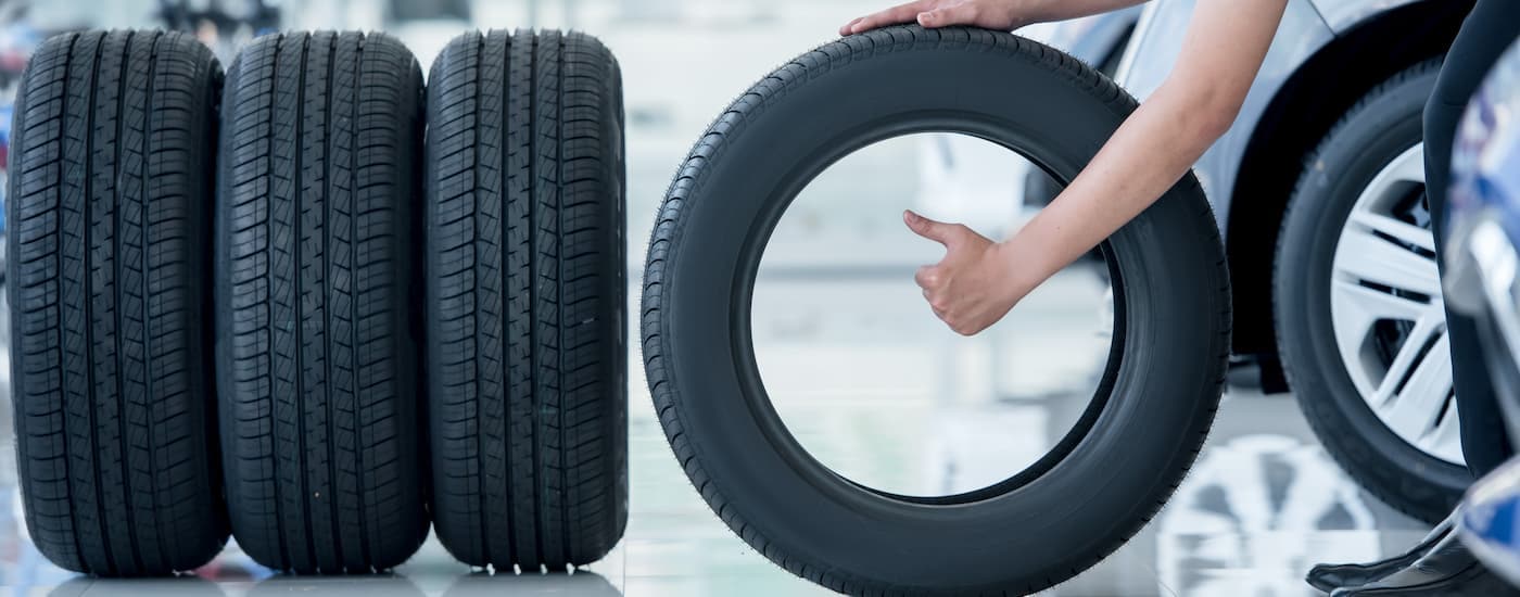 A mechanic is shown inspecting a set of tires at a Lincoln service center near Queens.
