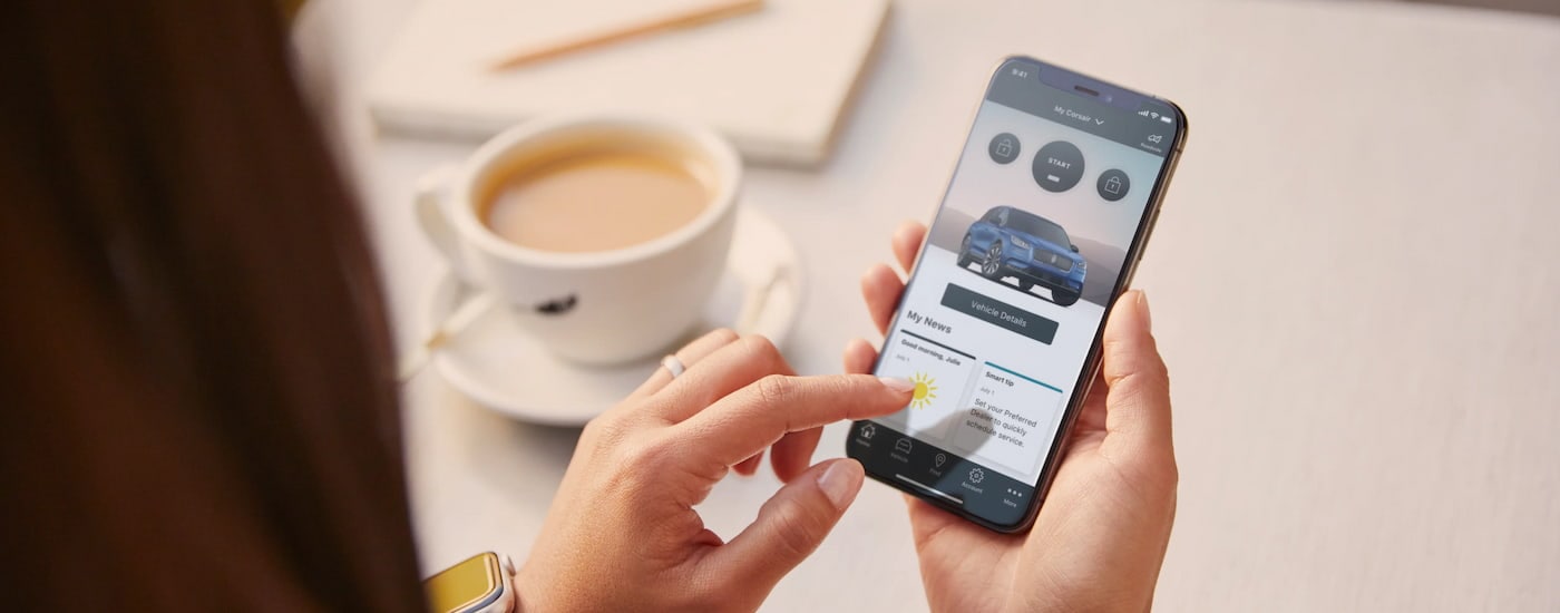 A close up of a person using the Lincoln phone app for service is shown.