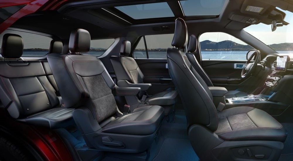 The black interior of a 2021 Ford Explorer, with two rows of seats and moonroof.