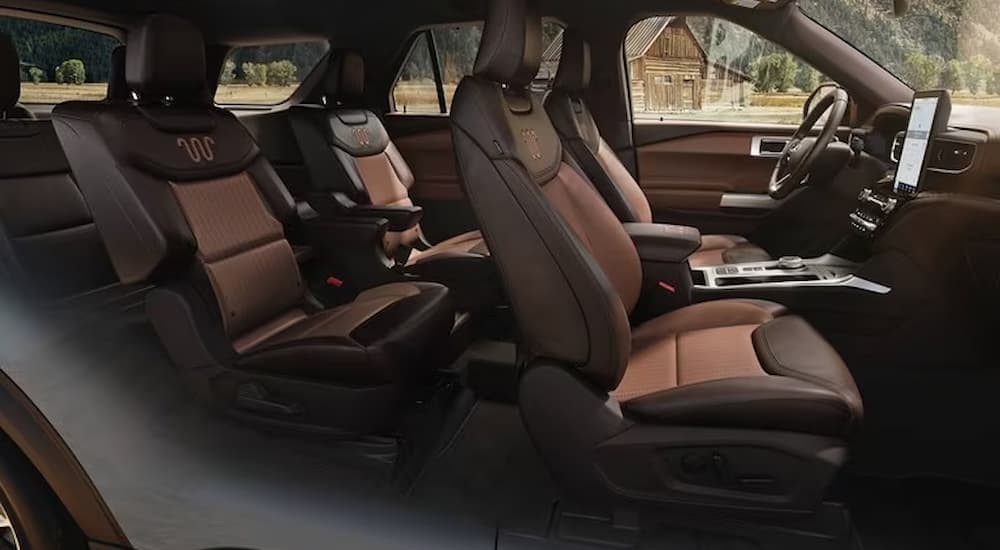 The black and brown interior of a 2023 Explorer King Ranch with two rows of seating.
