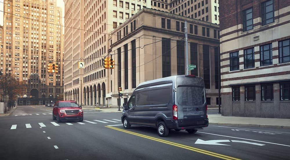 A gray 2024 Ford Transit van driving through New York City. 