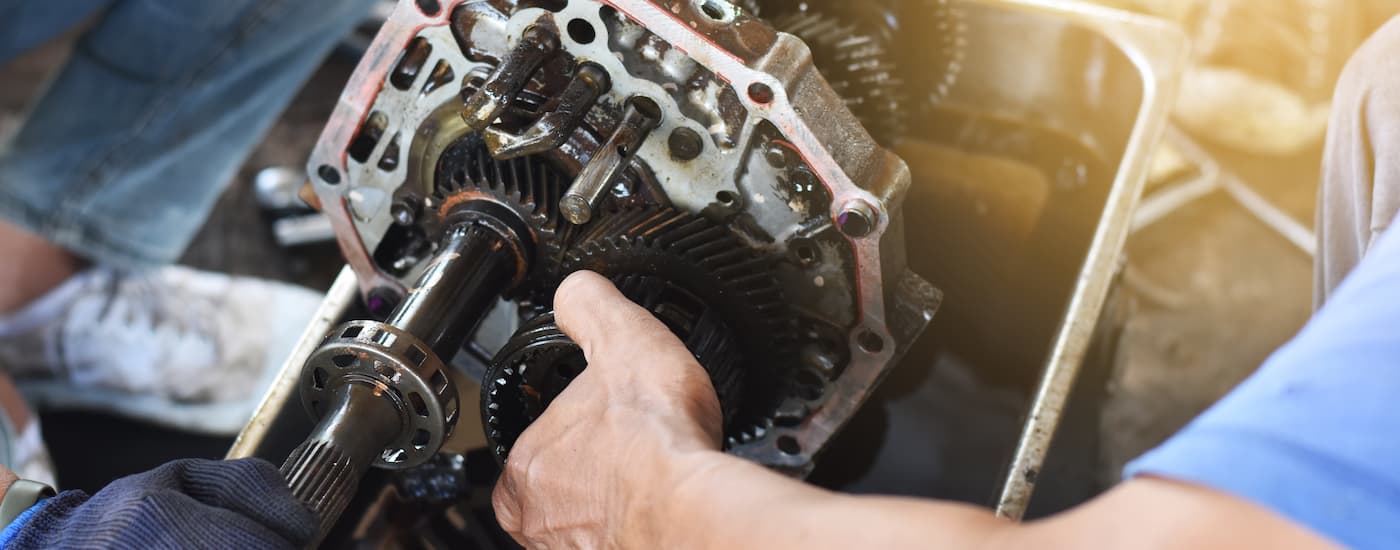 A mechanic is shown fixing a transmission while doing car repairs in Bay Ridge.