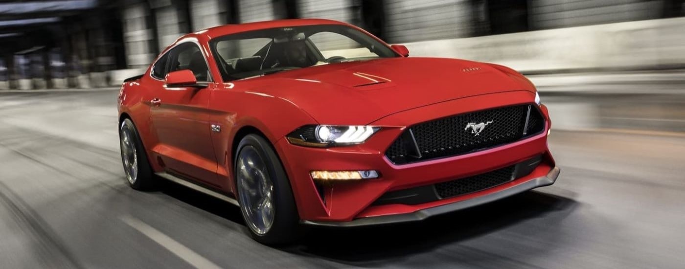 A red 2023 Ford Mustang GT driving through a tunnel toward a Ford dealer near you.