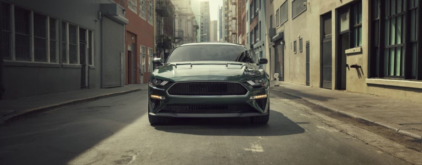 A green 2020 Ford Mustang BULLITT is parked in an alleyway after visiting a Bay Ridge Ford dealer.