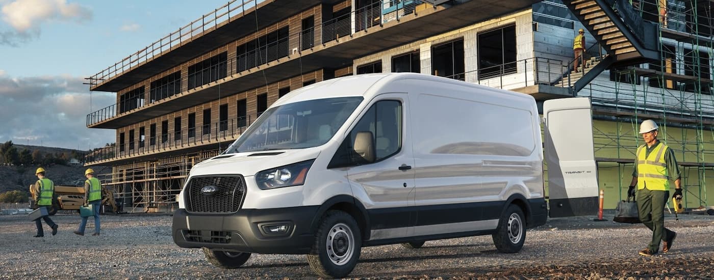 A white 2024 Ford Transit parked at a construction site.