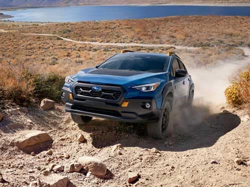 2023 Subaru Crosstrek Wilderness driving up a dirt hill