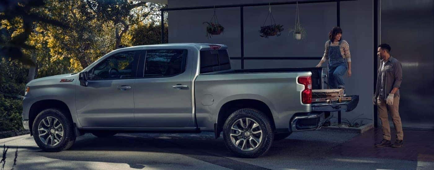 A couple loading the bed of their silver 2026 Chevy Silverado 1500 LT