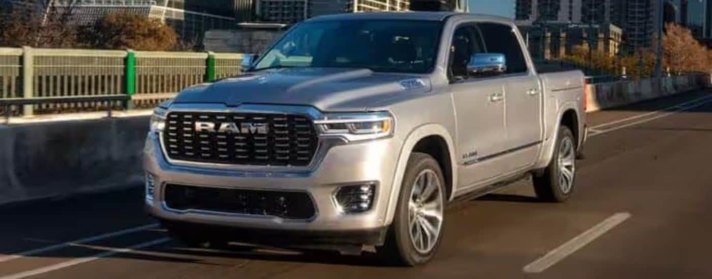 A silver 2025 Ram 1500 is shown driving on a bridge