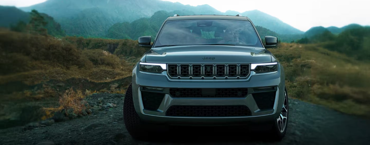 Silver 2026 Jeep Grand Cherokee driving along a beach