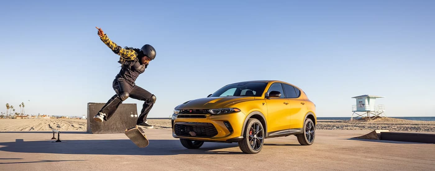 A gold 2024 Dodge Hornet is parked next to a skateboarding park.