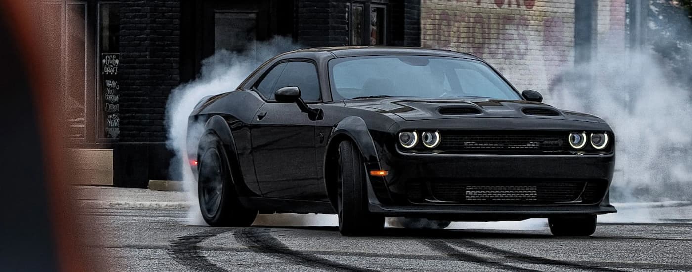 A black 2022 Dodge Challenger SRT Hellcat Redeye is kicking up smoke after shopping for a used Dodge for sale.