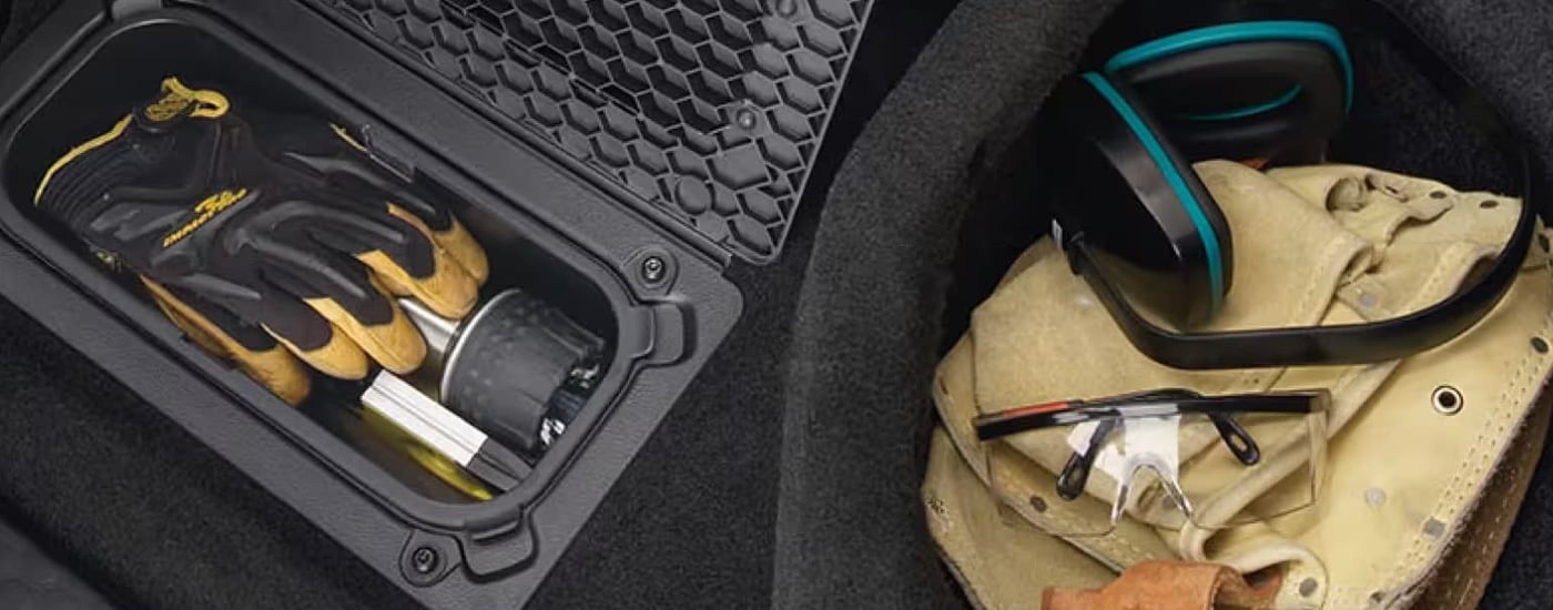 A bunch of work gear is in the storage bins in a 2024 Ram 2500 HD.
