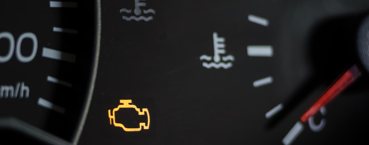 A close up of a vehicle's dashboard with warnining lights lit up.