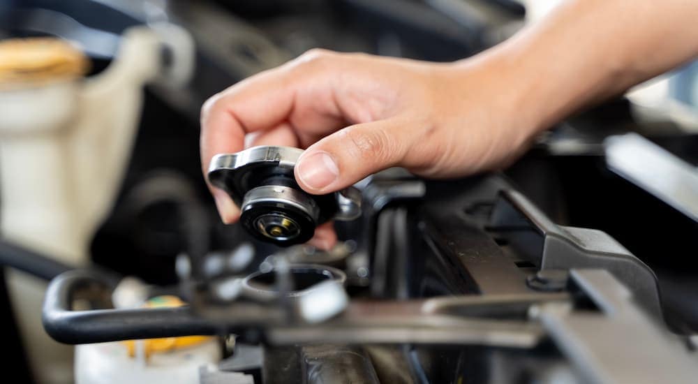 A mechanic is checking the coolant levels in a vehicle.