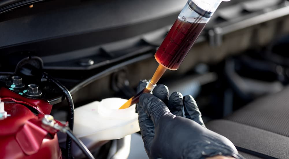 Close-up of a mechanic replacing brake fluid.