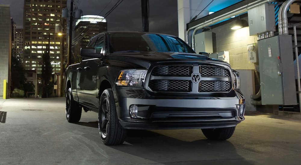 A black 2022 Ram 1500 Classic is parked on a city street at night.