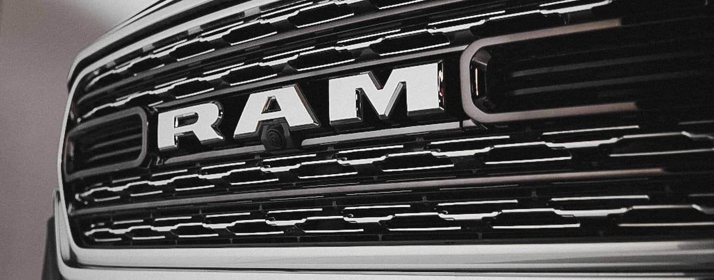A close up of a silver grille on a used 2022 Ram 1500 for sale.