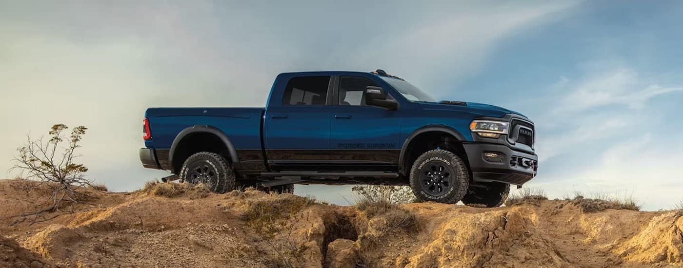 A dark blue 2024 Ram 2500 Power Wagon is shown from the side after leaving a Ram dealer.