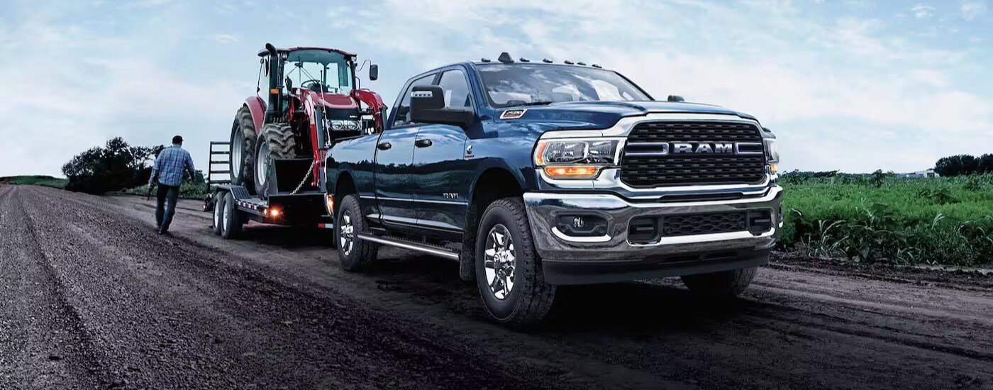 A popular Ram 2500 for sale, blue 2024 Ram 2500 Laramie, is shown towing a trailer.