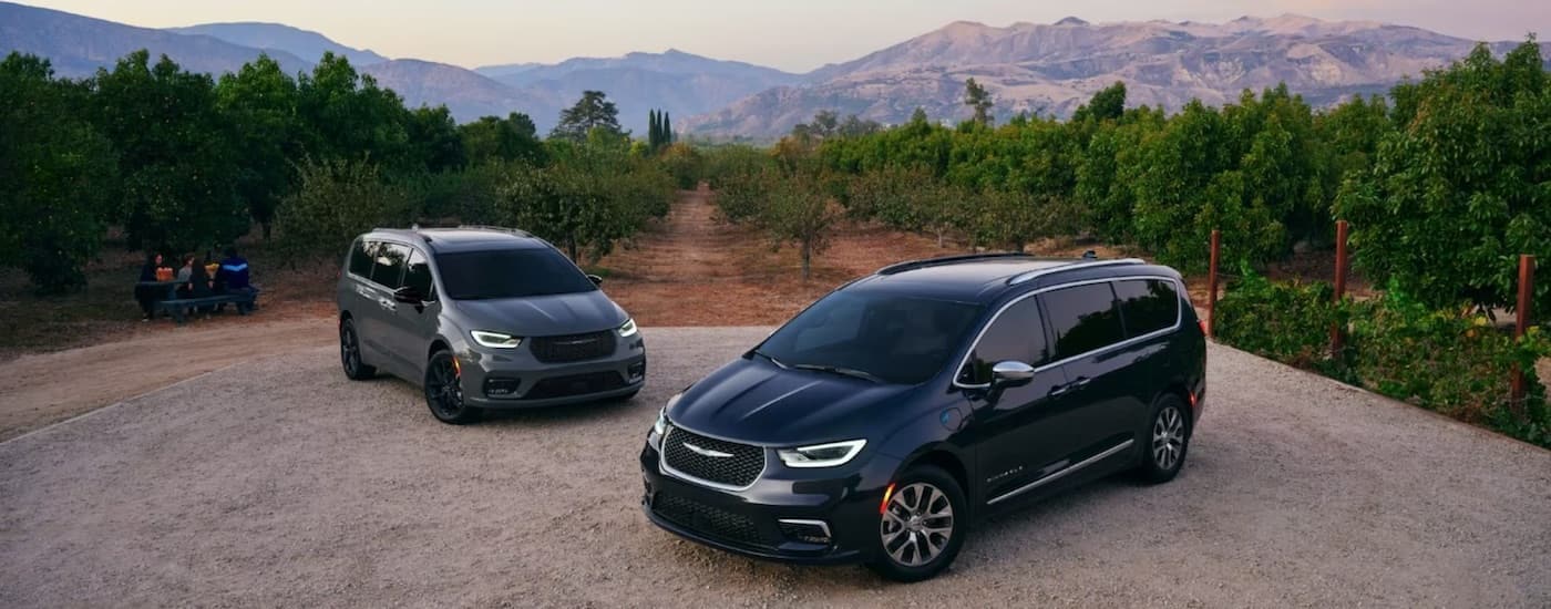 A grey and a black 2024 Chrysler Pacifica are shown parked after leaving a Chrysler dealer.