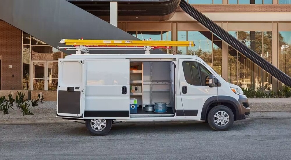 Side view of a white 2024 Ram ProMaster Cargo Van with its doors open.