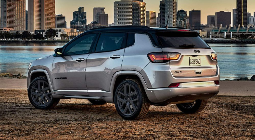 A grey 2024 Jeep Compass is shown overlooking a city.