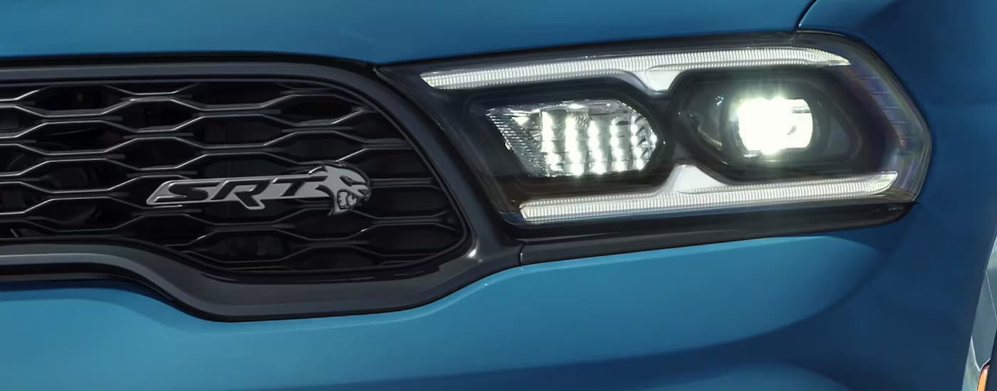 A close up of the headlight of a blue 2024 Dodge Durango SRT 392 at a Dodge dealer.