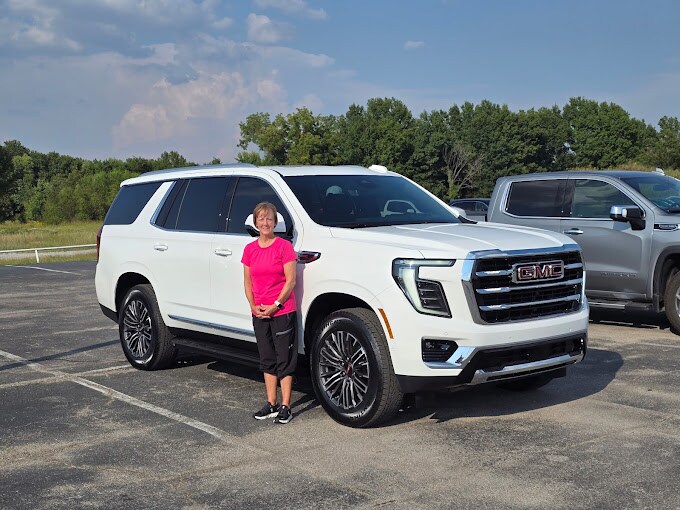 Happy couple posing next to a recently purchased GMC truck near Sand Springs, OK