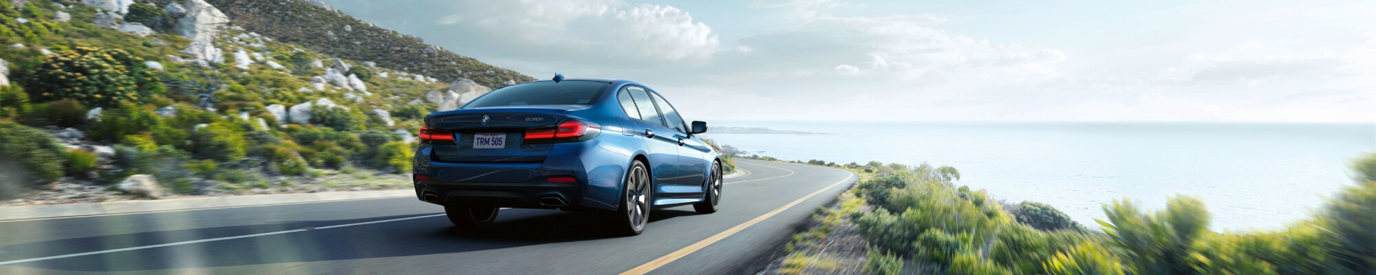 New BMW 5 series driving by the coast
