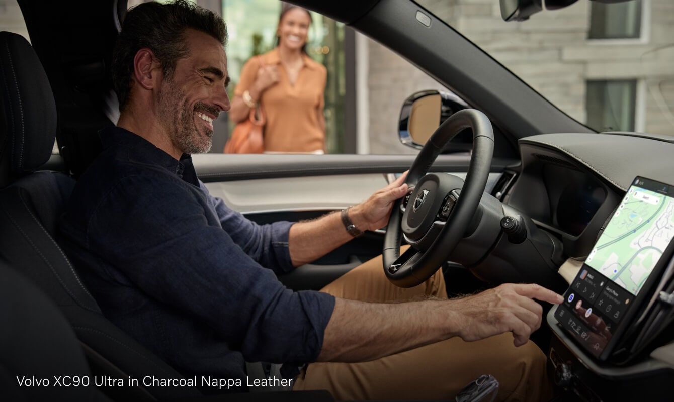 Volvo XC90 driver using the central touchscreen infotainment system.