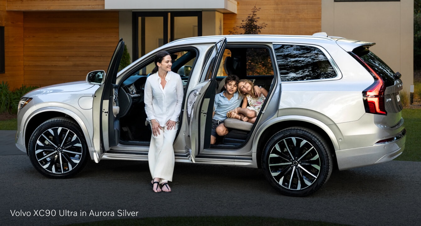 Volvo XC90 parked with open doors on a modern residential driveway.