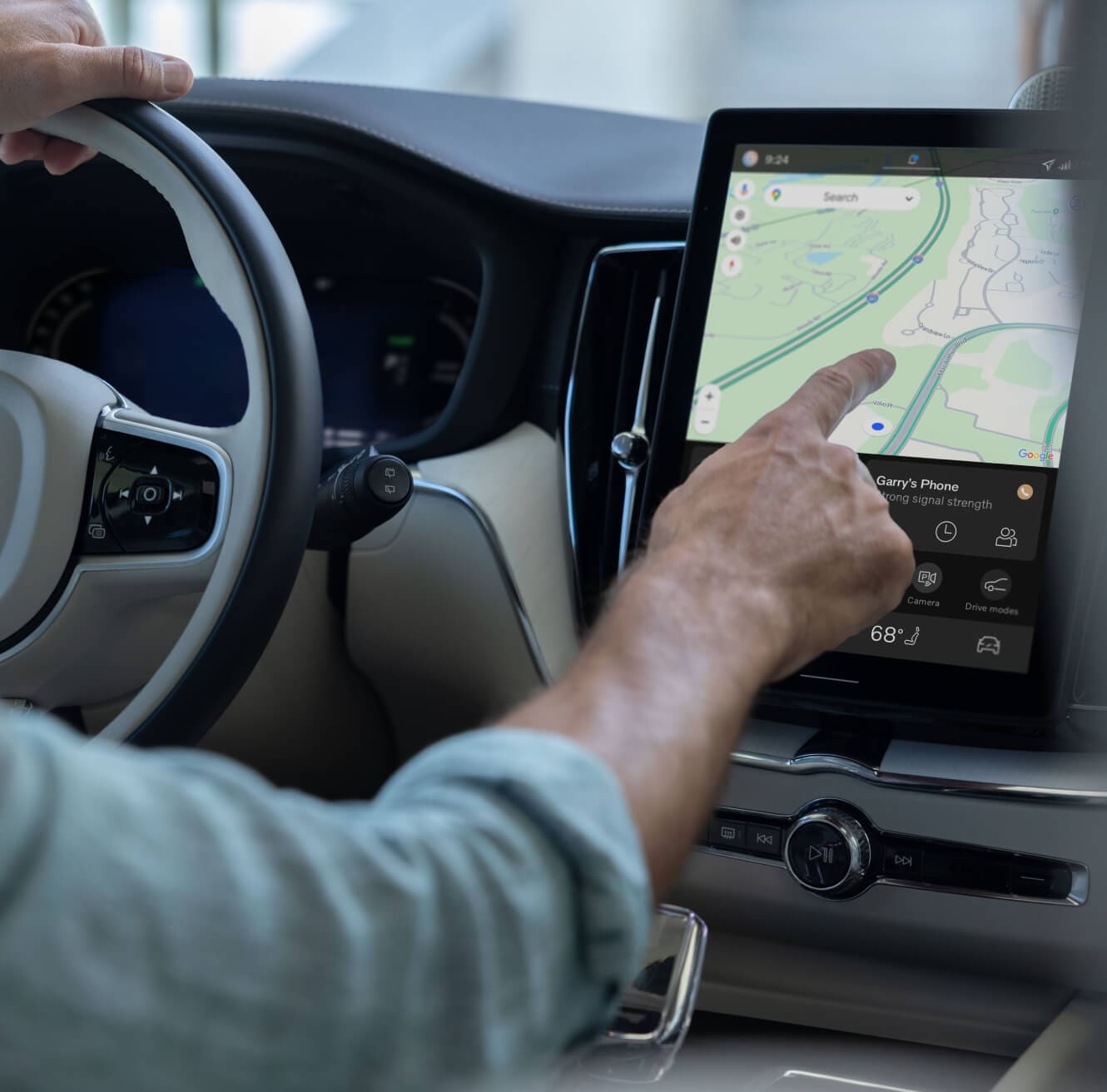 interior close-up of a driver interacting with the Volvo XC60 intotainment system touchscreen.