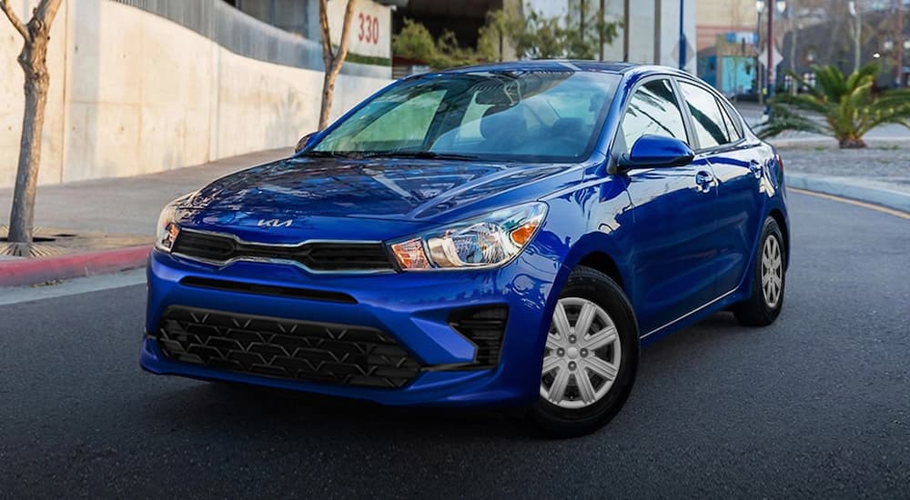 A blue 2022 Kia Rio is shown parked on a city street after visiting a Kia dealer near you.