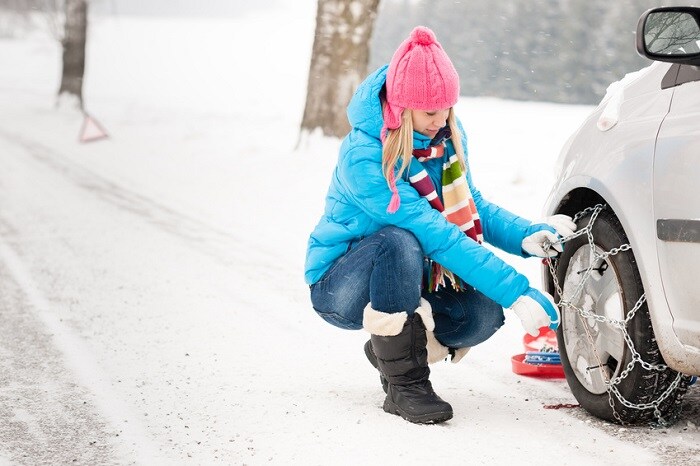 Woman_Putting_Winter_Chains_On_Tires_Snow.jpg